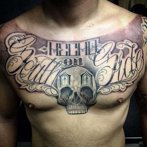 Chicano tatuagem no peito de um cara de crânio e inscrição