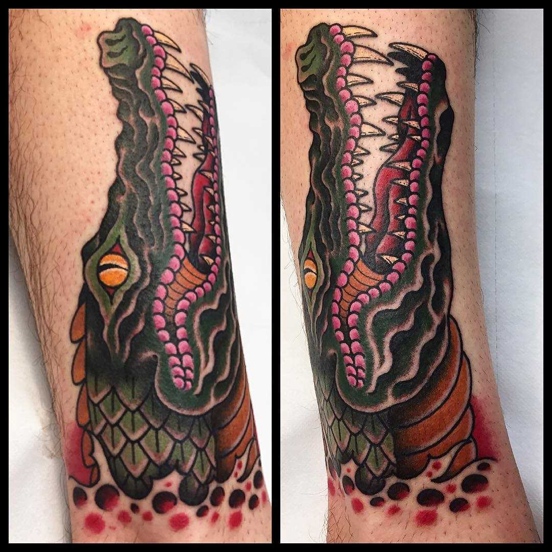 Cores de tatuagem de crocodilo sobre a perna de um cara