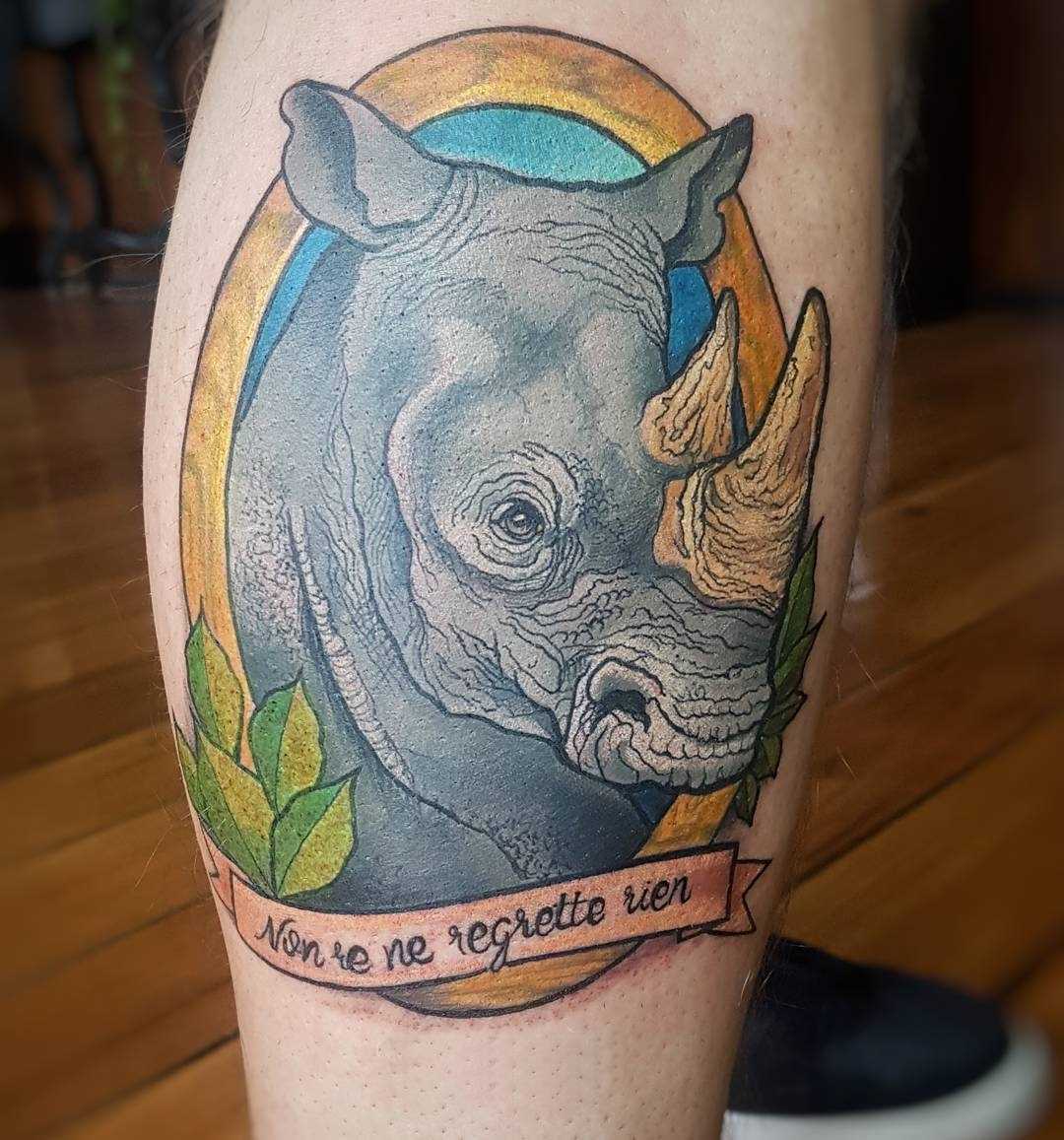 Cores de tatuagem de rinoceronte, com os dizeres sobre a perna de um cara