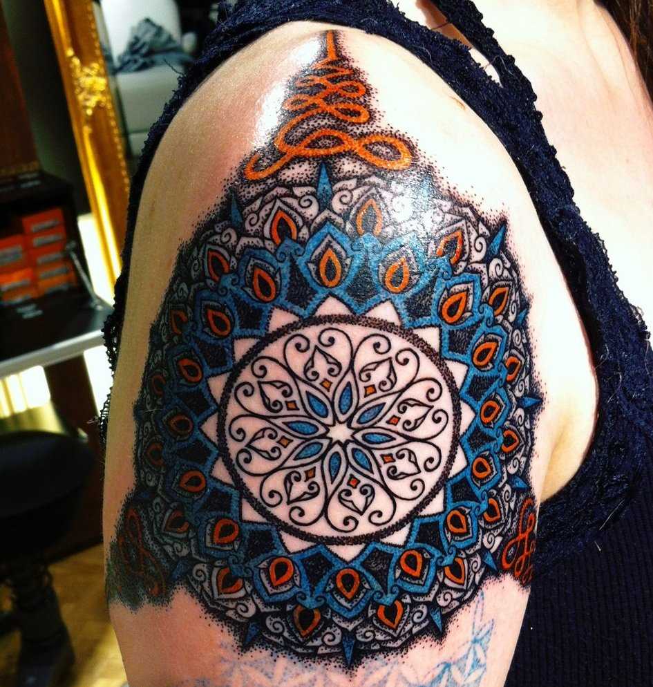 Cores de tatuagem no ombro da menina em forma de mandala