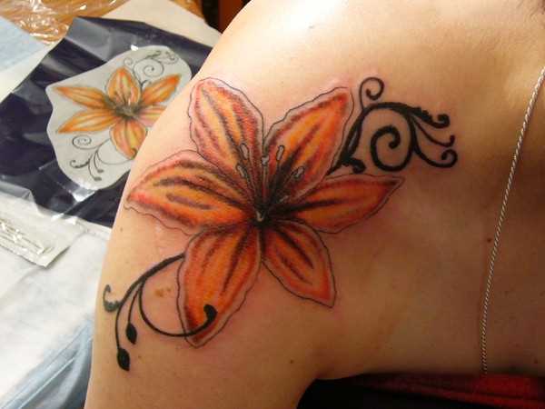 Cores de tatuagem no ombro da menina - o lírio com um padrão de