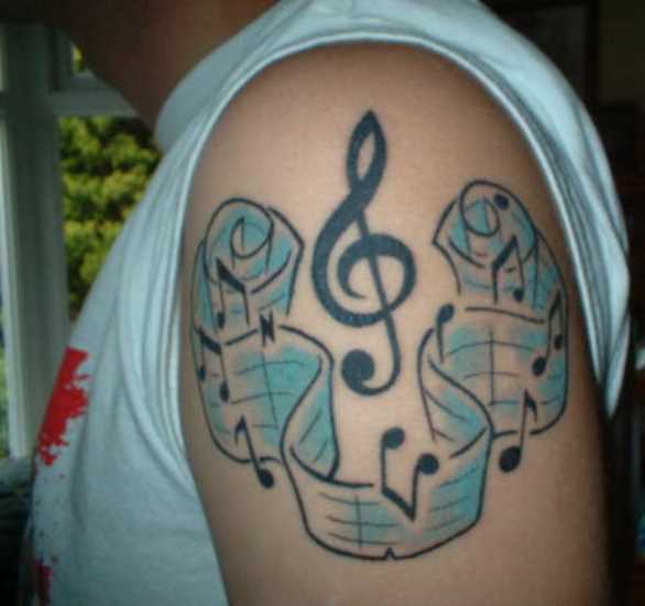 Cores de tatuagem no ombro de um cara - a clave de sol e notas