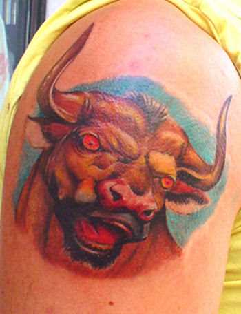 Cores de tatuagem no ombro de um cara com a imagem de um touro