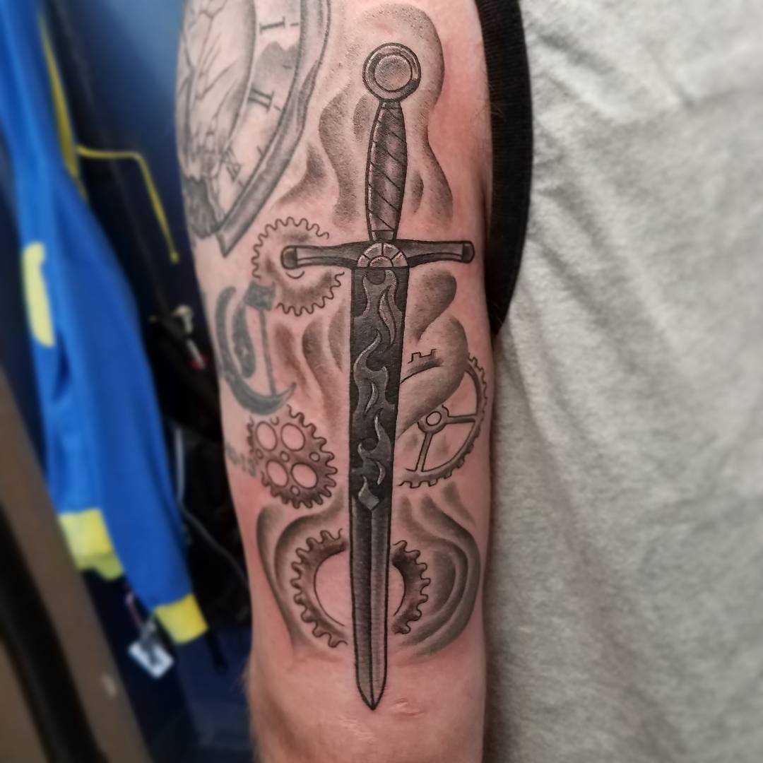 Desenho de uma espada no ombro do homem