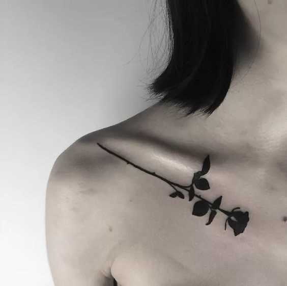 Esta foto de uma linda tatuagem de rosas no estilo blackwork na clavícula menina