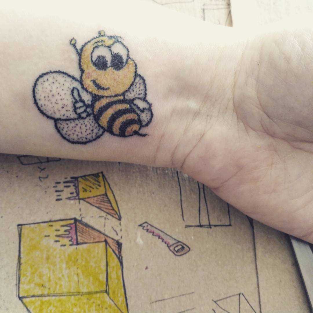 Foto a cores de tatuagem de abelha no estilo handpoke no pulso cara