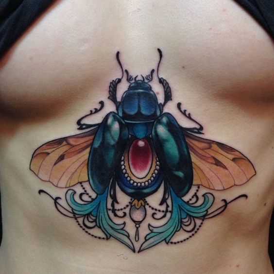 Foto a cores de tatuagem de escaravelho em estilo egípcio no peito da menina