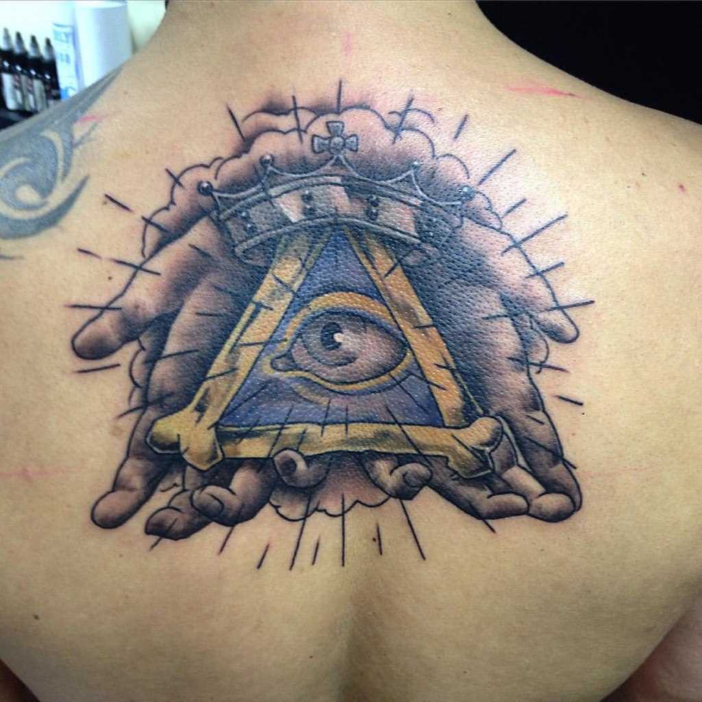 Foto a cores de tatuagem que tudo vê piscar de olhos com as mãos nas costas do cara