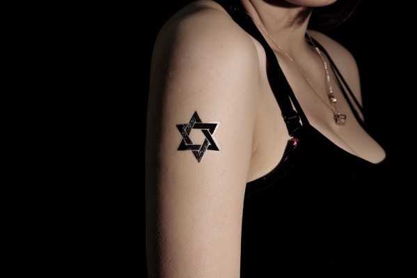 Foto da tatuagem da estrela de david no bairro judeu de estilo no ombro da menina