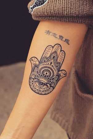 Foto da tatuagem da mão de fátima, em estilo indiano no antebraço da menina