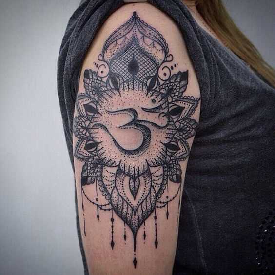 Foto da tatuagem do símbolo om no estilo indiano no ombro da menina