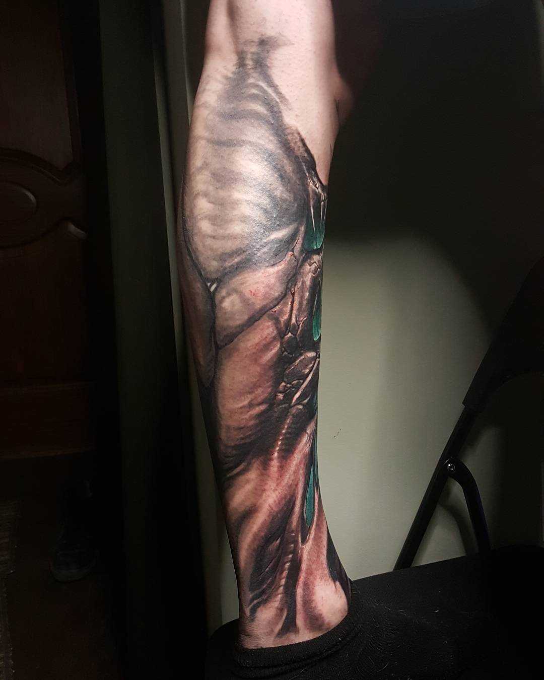 Foto da tatuagem em estilo organika sobre a perna de um cara