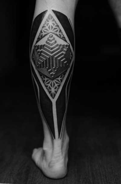 Foto da tatuagem no estilo de blackwork sobre a perna de um cara