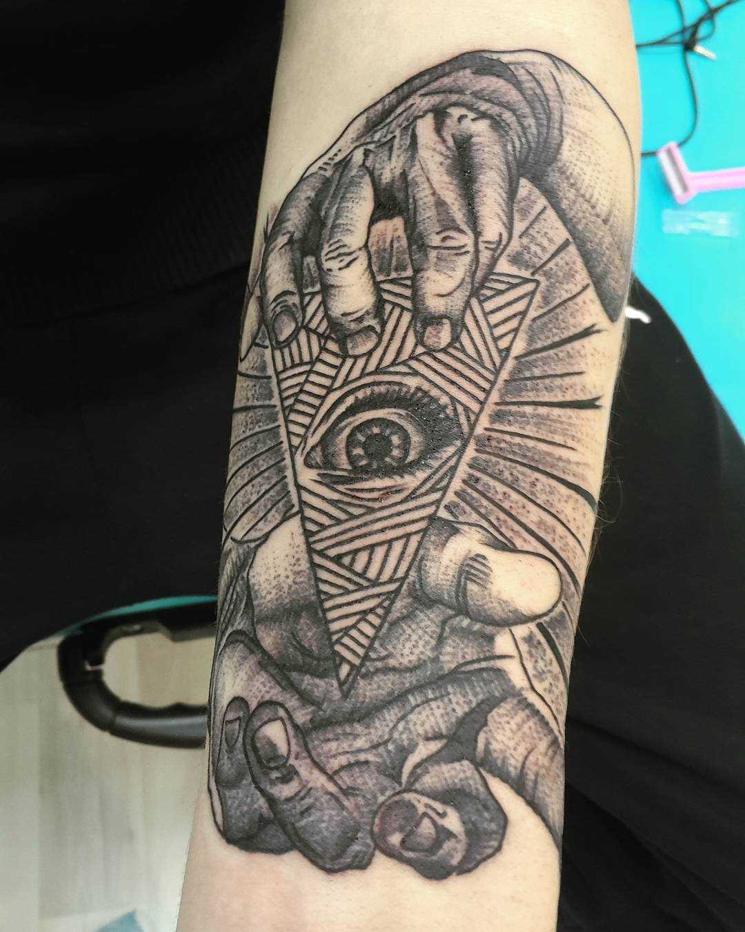 Foto de quadro de tatuagem piscar de olhos que tudo vê na mão de um cara