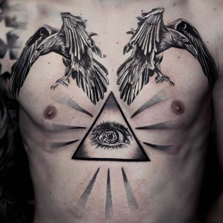 Foto de um grande tatuagem piscar de olhos que tudo vê com os pássaros no peito do cara