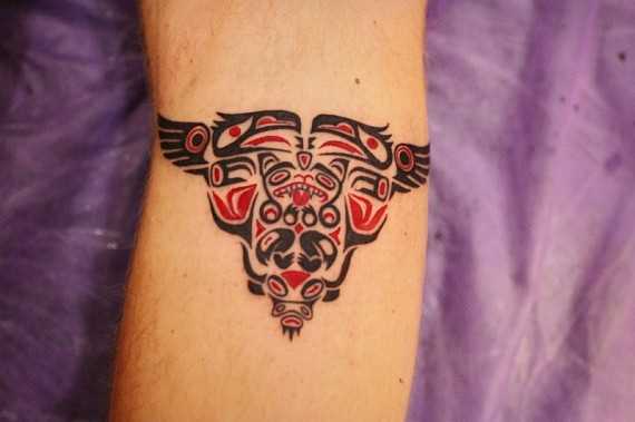 Foto de uma pequena tatuagem no estilo de haida no cotovelo do cara
