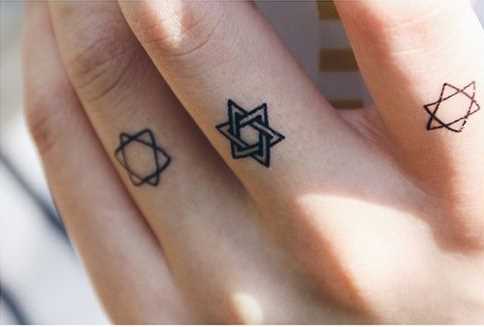 Foto de uma tatuagem de estrela de davi em hebraico estilo dos dedos de um cara