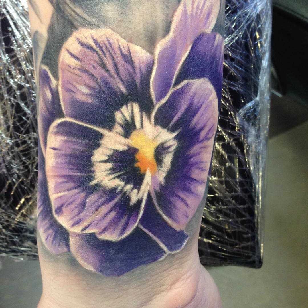 Foto de uma tatuagem de violeta no pulso da menina