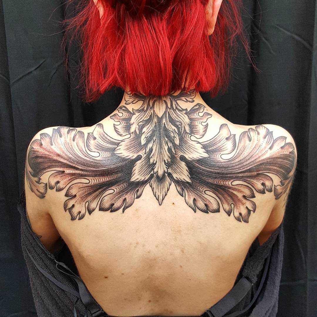Foto de uma tatuagem em estilo barroco na parte de trás da menina