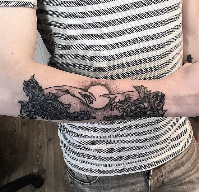 Foto de uma tatuagem em estilo barroco no antebraço cara
