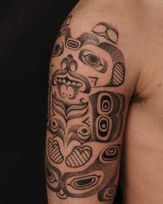 Foto de uma tatuagem em estilo haida no ombro de homens