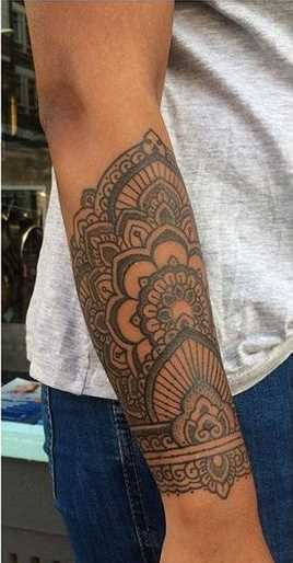 Foto de uma tatuagem em estilo indiano no antebraço cara