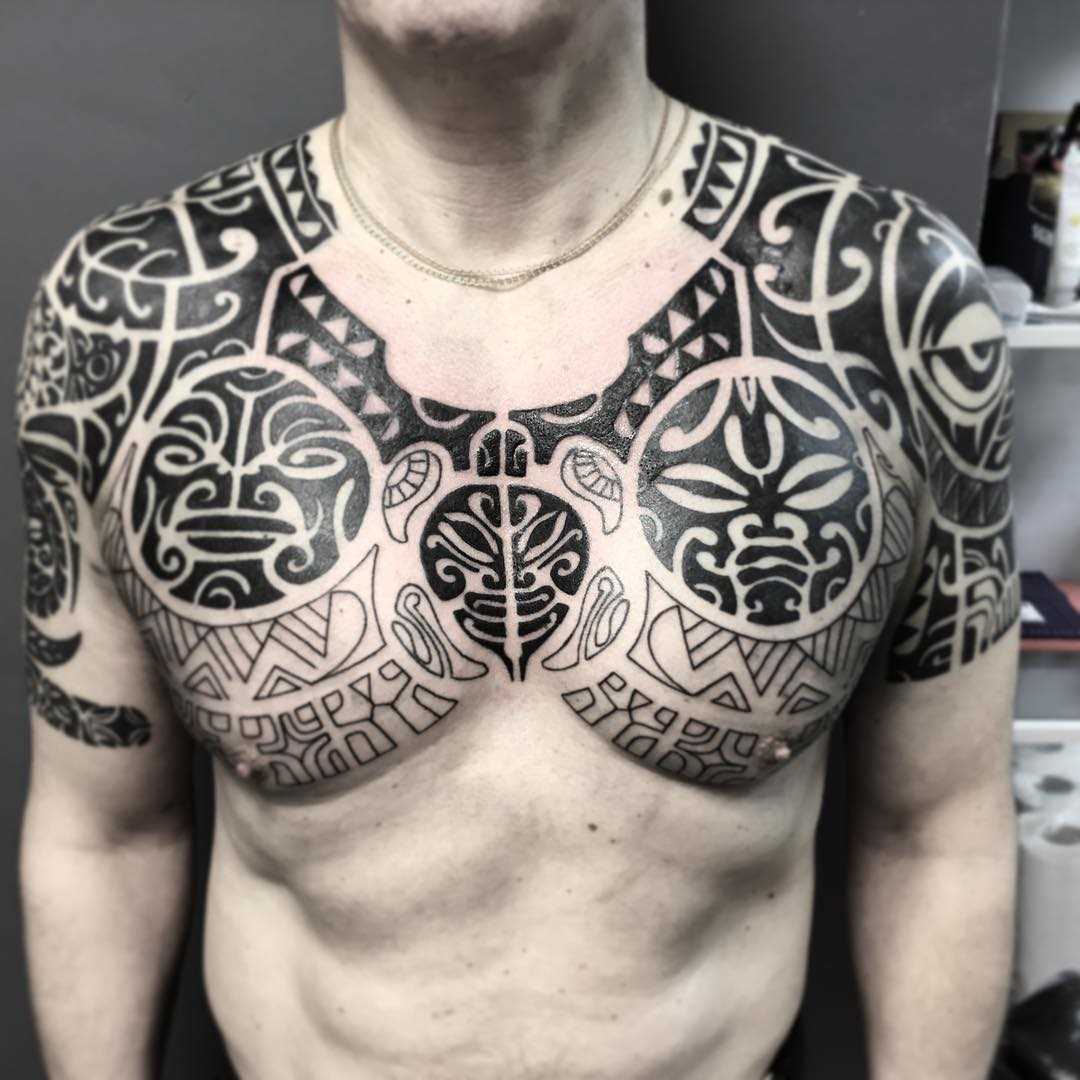 Foto de uma tatuagem em estilo polinésia na cara no peito