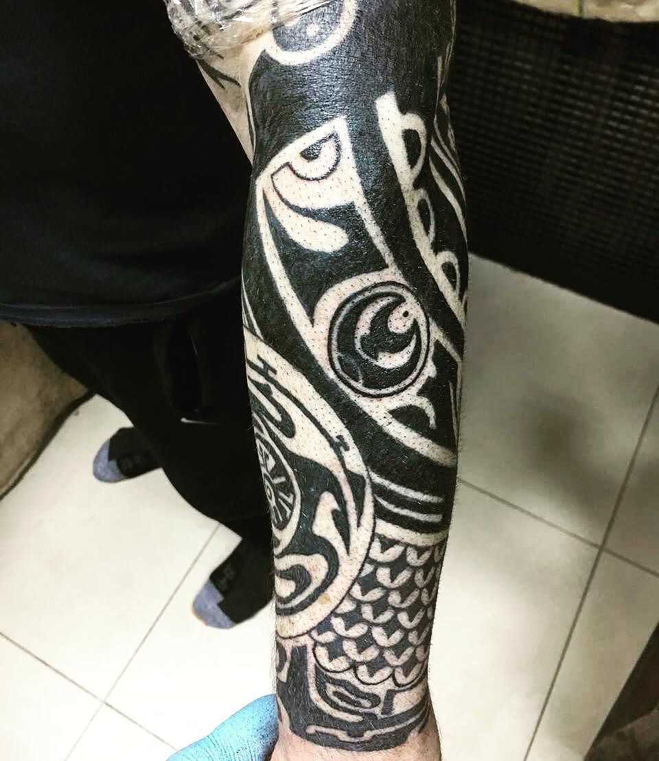 Foto de uma tatuagem em estilo polinésia na manga cara