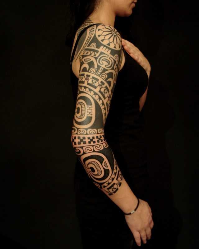 Foto de uma tatuagem em estilo polinésia na manga da menina