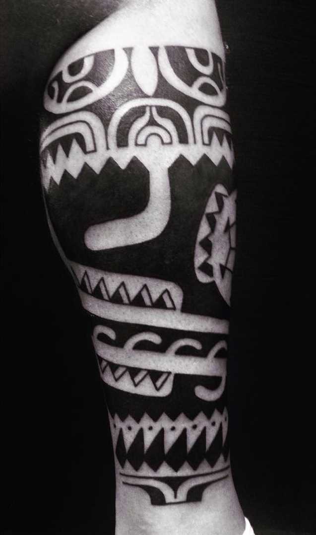 Foto de uma tatuagem em estilo polinésia sobre a perna de um cara