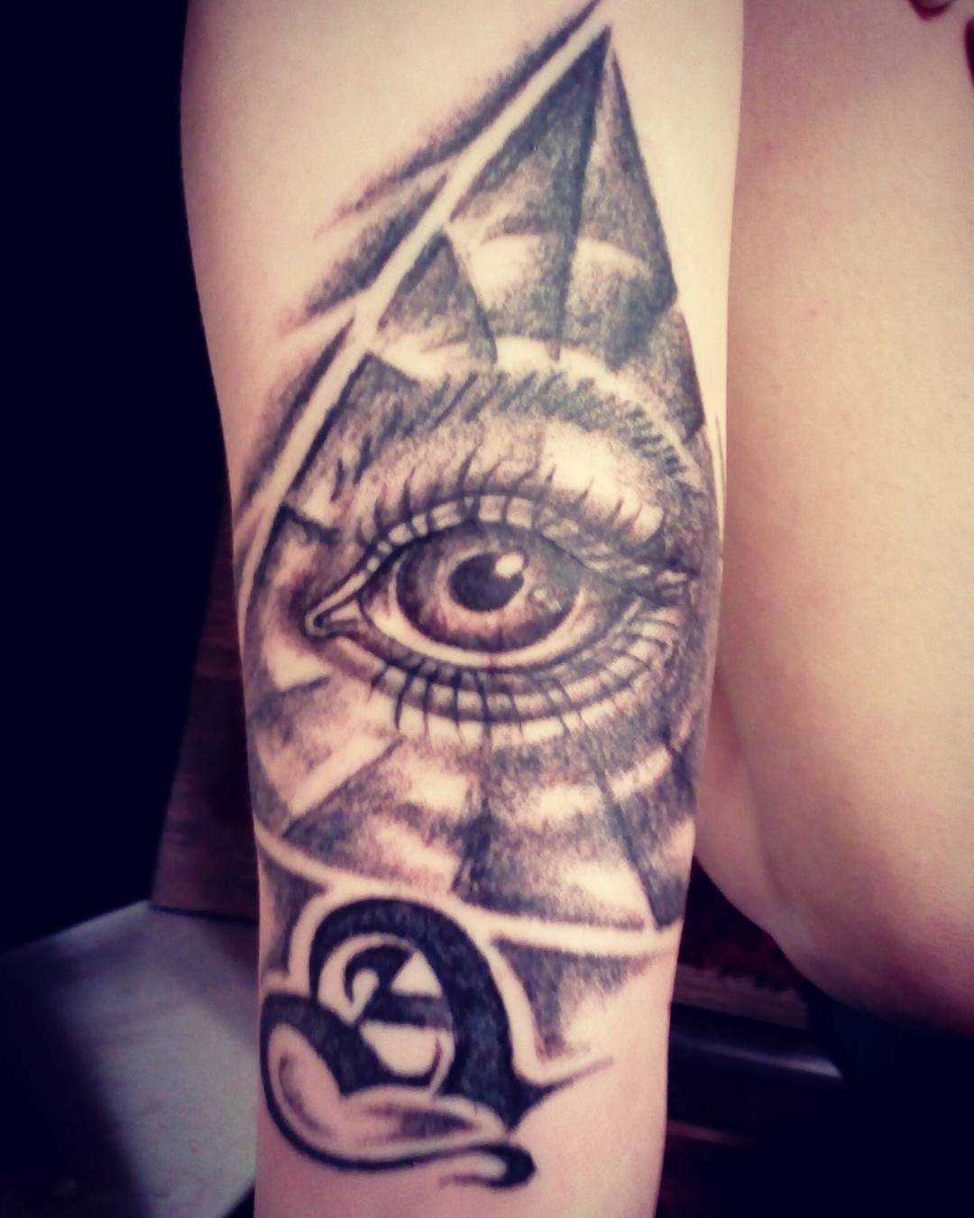 Foto de uma tatuagem que tudo vê piscar de olhos na mão de um cara