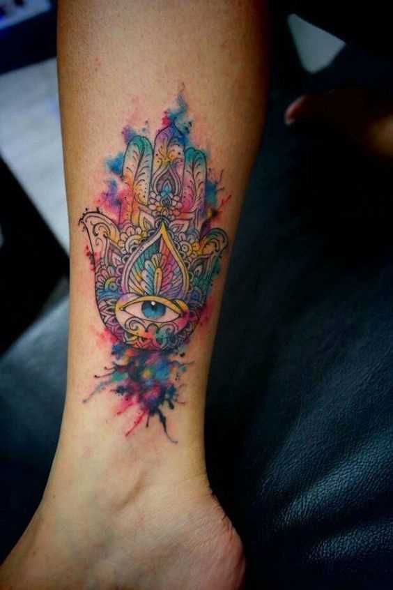 Foto do tattoo da mão de fátima, em estilo indiano sobre a perna da menina