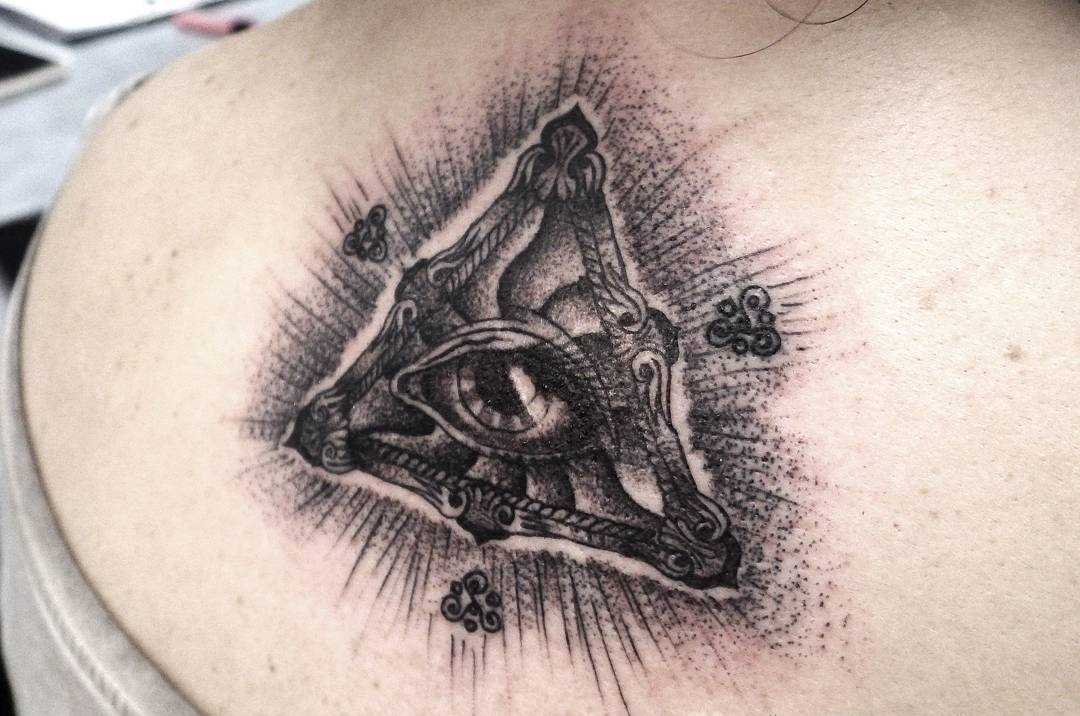 Foto íngreme da tatuagem piscar de olhos que tudo vê na parte de trás da menina