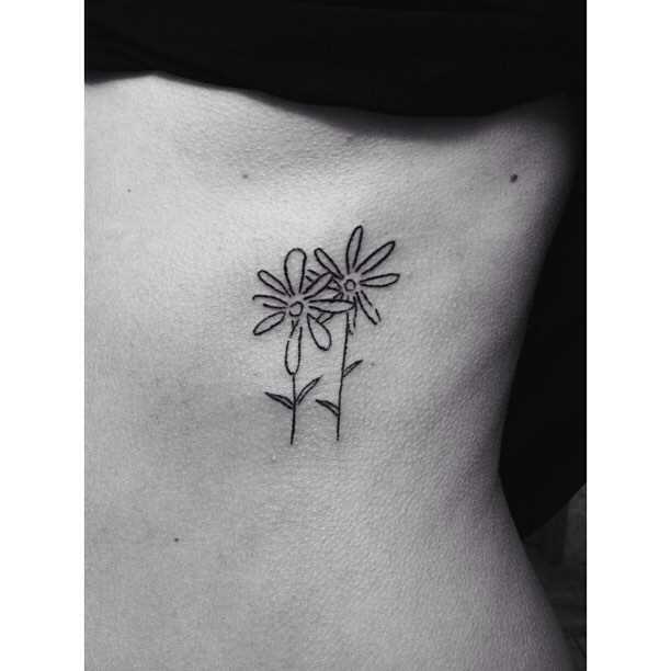 Fotos de tatuagem de flores no estilo handpoke sobre as costelas menina