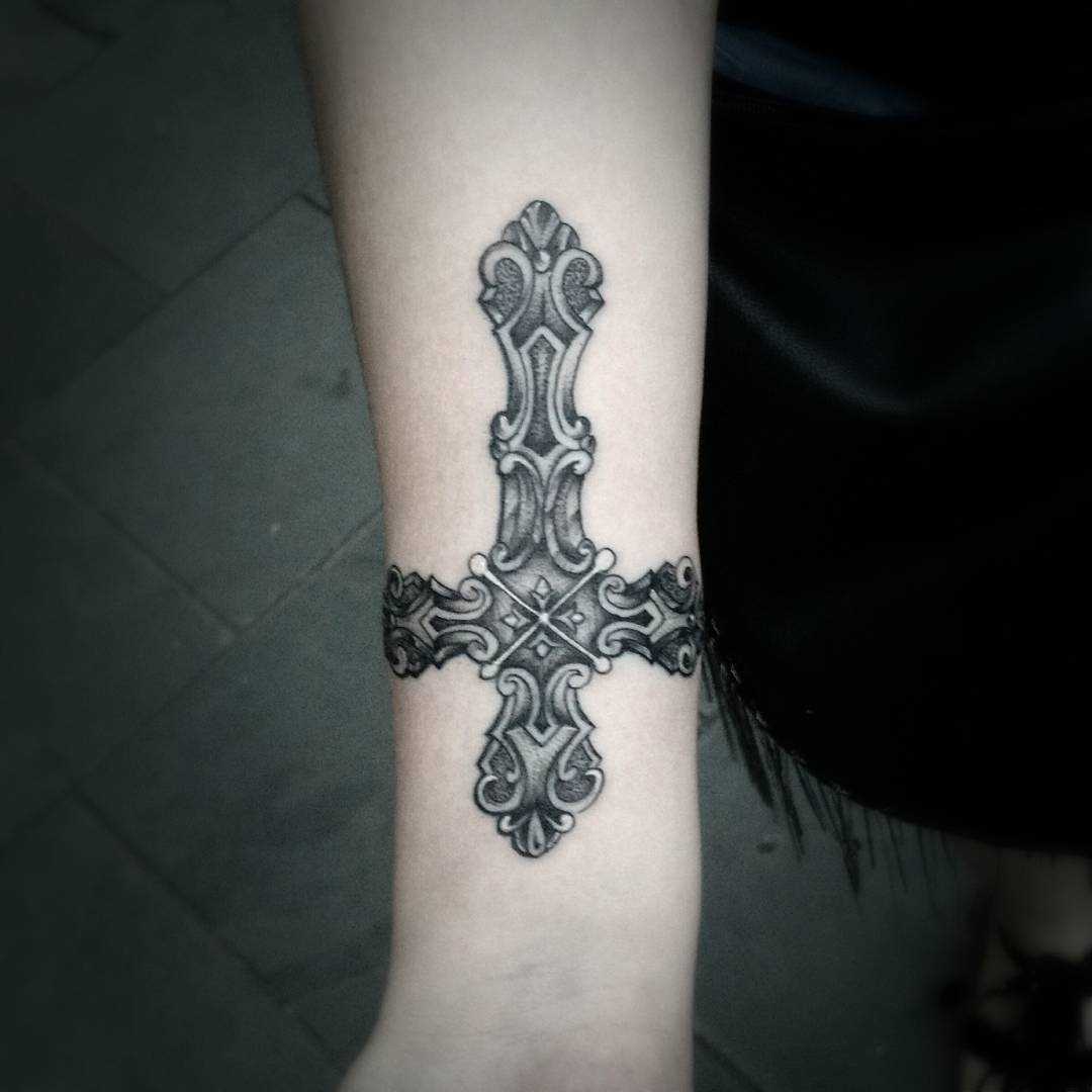 Fotos de tatuagem de uma cruz em estilo gótico no antebraço da menina