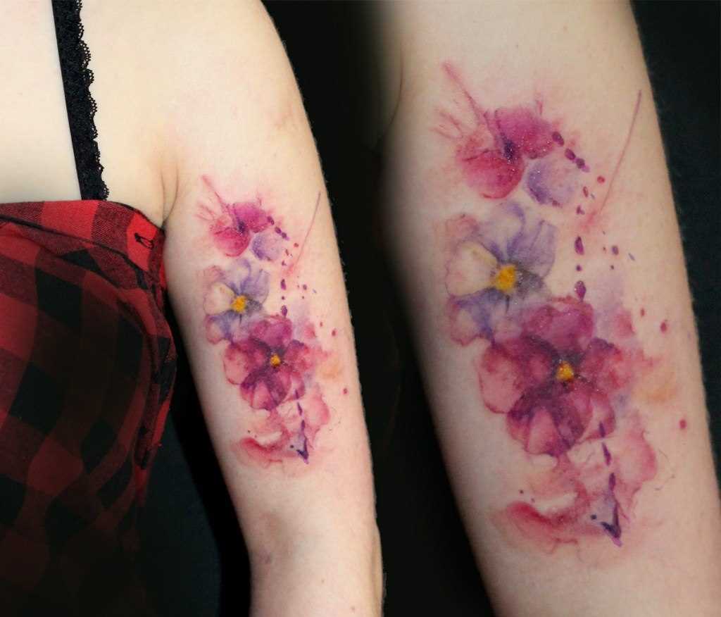 Fotos de tatuagem de violetas no estilo aquarela na mão da menina