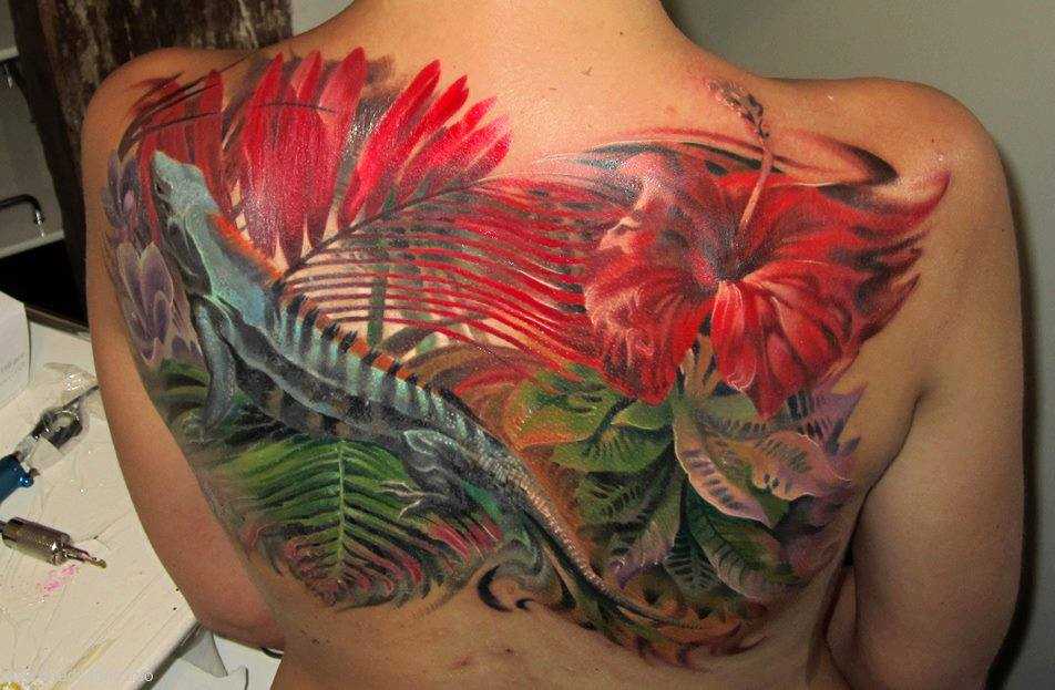 Grande belo tatuagem nas costas de uma menina em forma de lagarto da flor
