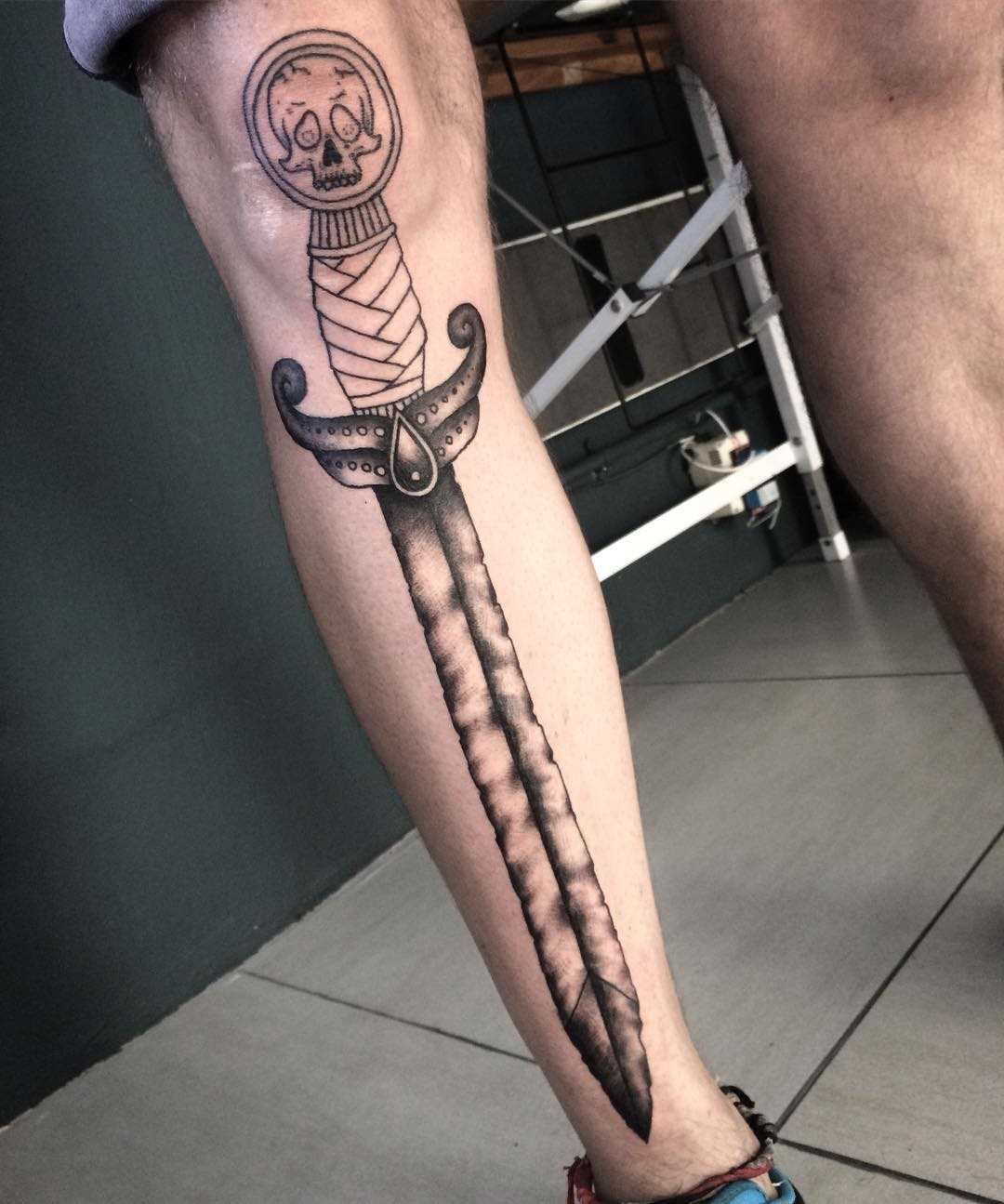 Íngreme desenho de uma espada sobre a perna de um cara