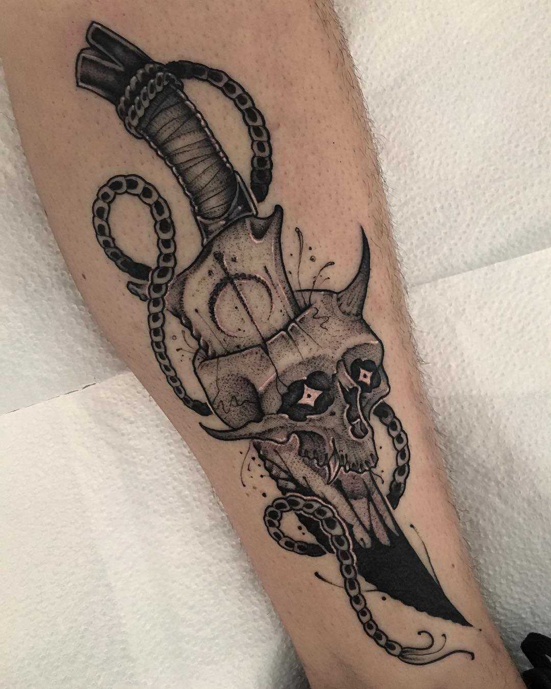 Legal a tatuagem de uma faca com uma caveira sobre a perna de um cara