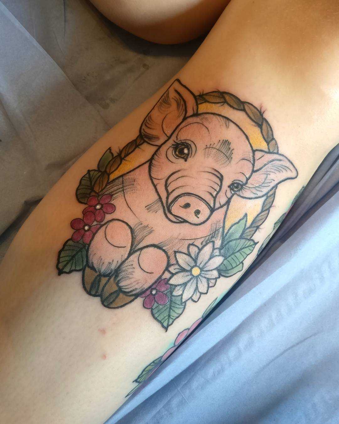 Linda tatuagem de porco sobre a perna da menina