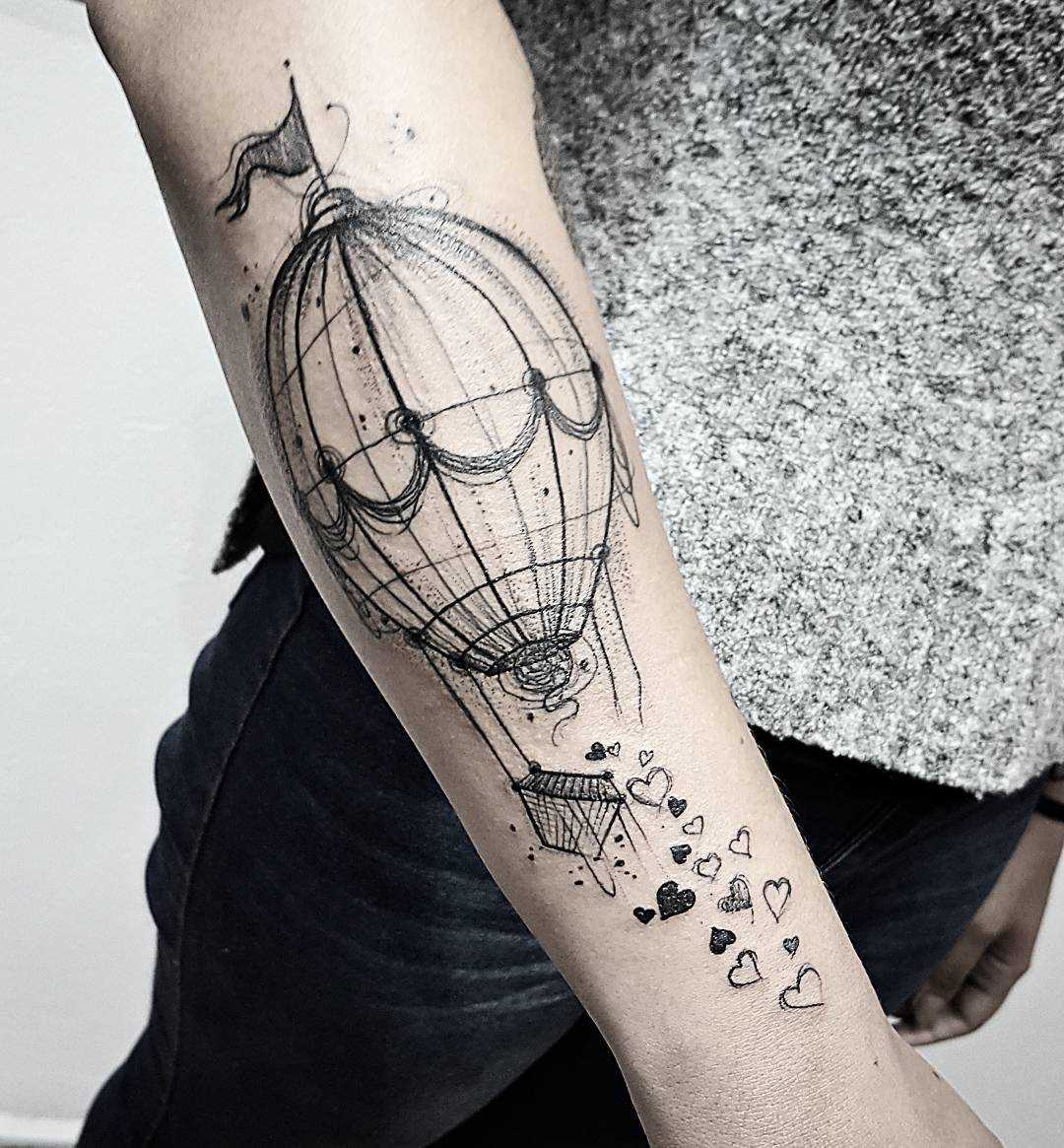 O desenho de um balão de ar no antebraço da menina