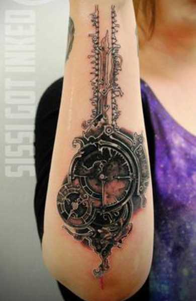 O estilo de biomecânica - a tatuagem no braço de uma menina - relógios