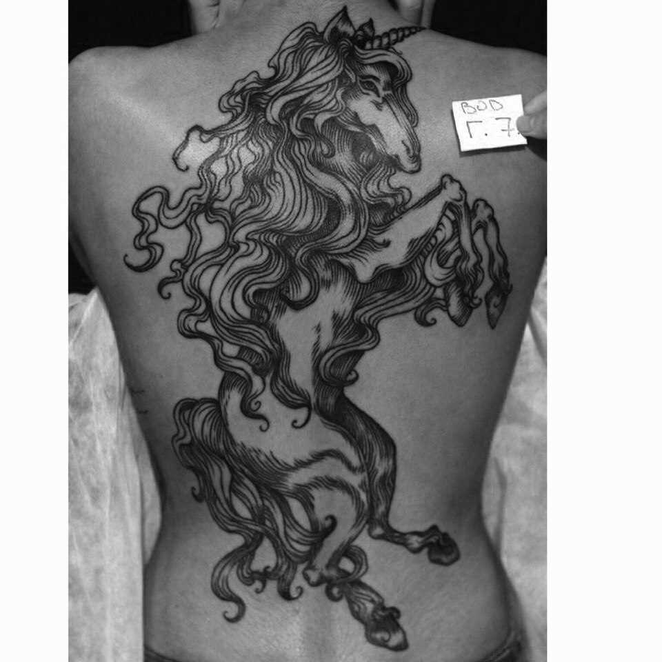 O unicórnio - a tatuagem nas costas de uma menina
