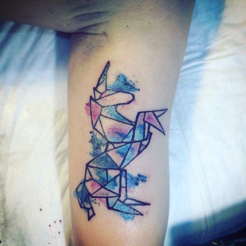 O unicórnio no estilo aquarela - tatuagem que tem no braço da menina