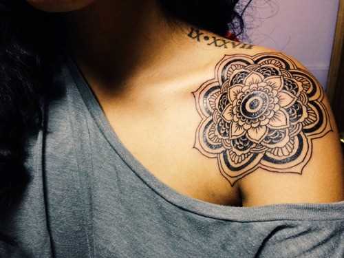Preto-e-branco de uma tatuagem no ombro da menina em forma de mandala