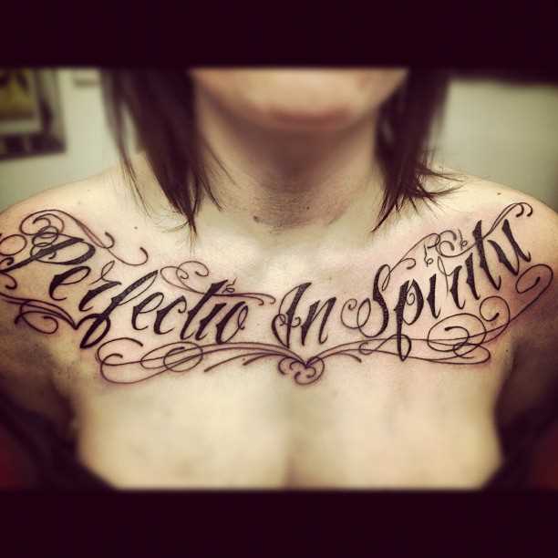 Tatuagem - a inscrição no peito da menina no estilo chicano