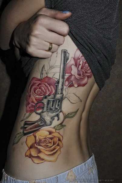 Tatuagem ao lado de uma menina - uma pistola e rosas