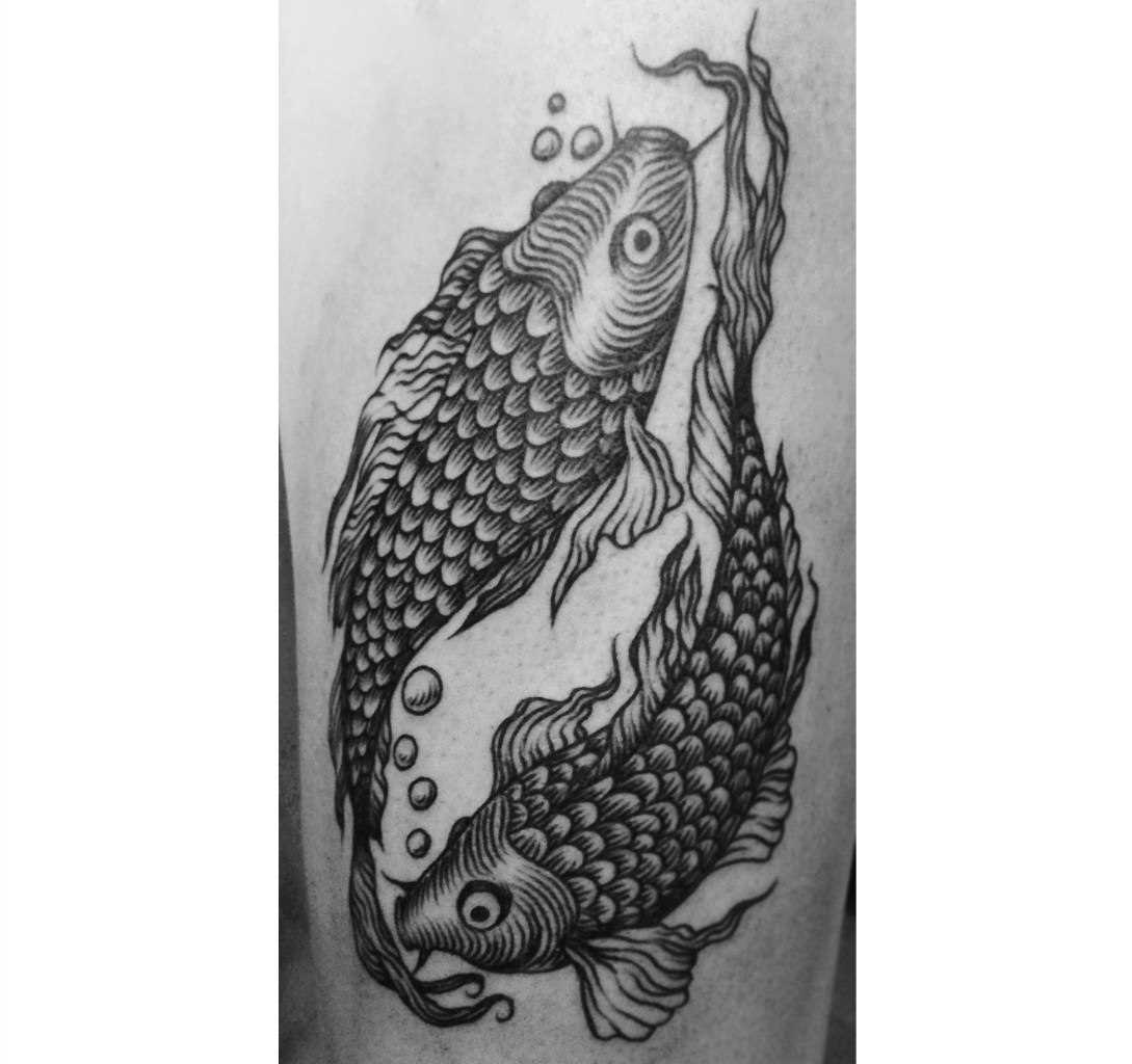 Tatuagem com peixes no quadril da menina