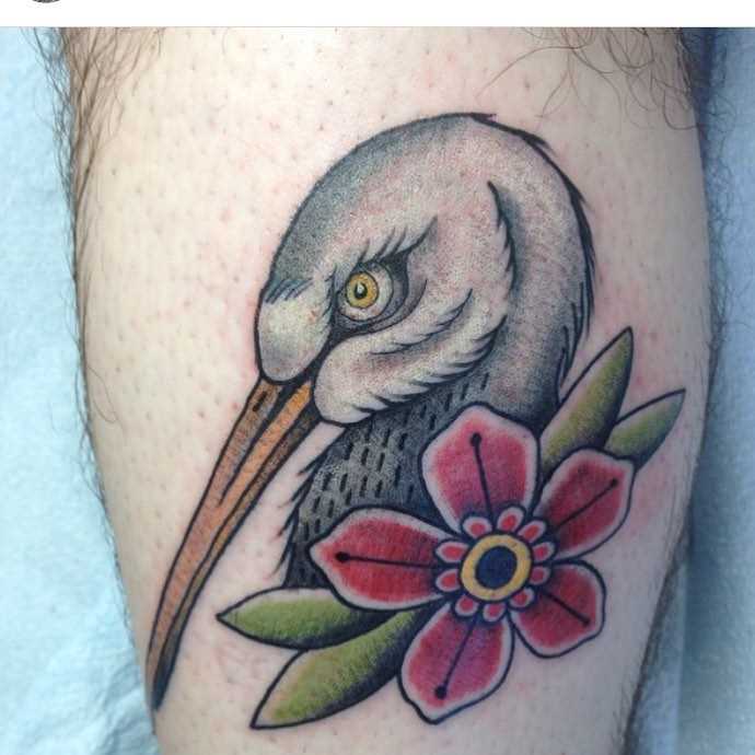 Tatuagem da cegonha com uma flor sobre a perna de um cara