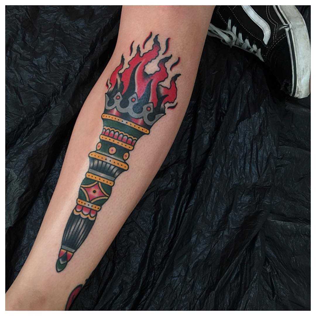 Tatuagem da tocha sobre a perna da menina